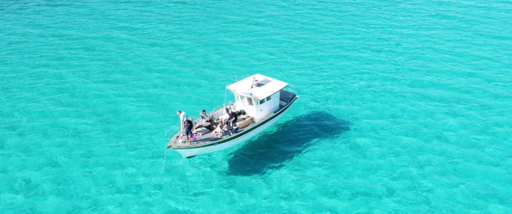 Motorboat in crystal-clear turquoise water with passengers on board